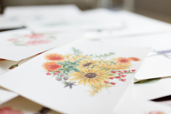 Sunflower and poppy bouquet of watercolor florals on paper, stacked on artist desk | Watercolor Paper Products for Wholesale, Dallas, Texas | By Caroline Ann
